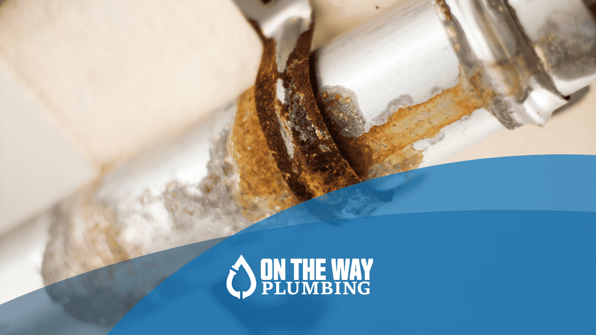Close-up of a severely corroded metal pipe with rust buildup, indicating aging plumbing and the need for whole-house repiping.