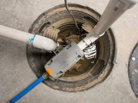 On The Way Plumbing installs and services sump pump drainage systems to prevent basement flooding—pictured, a basement floor drain for sump pump discharge