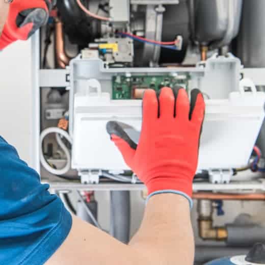 On The Way Plumbing technician repairing the electrical panel on a water heater for a safe and efficient fix.